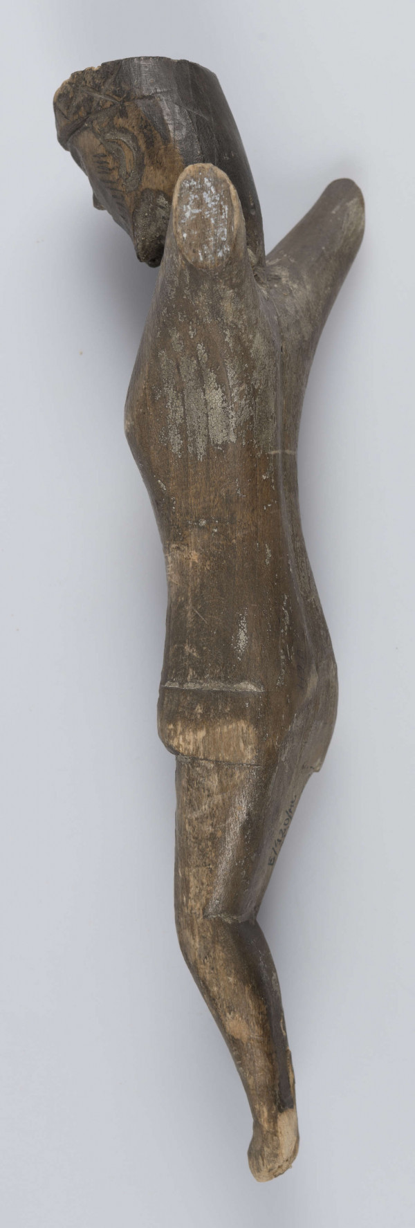 E/420/ML - Rzeźba wykonana techniką strugania i gładzenia z jednego kawałka drewna. Głowa lekko pochylona ku przodowi i w prawo. Perizonium schematyczne, twarz stylizowana, oczy zamknięte, na ustach widoczny smutek. Korona cierniowa zaznaczona wyraźnie - ciernie symboliczne - wgłębne iksy oraz kropki. Rzeźba niepolichromowana.