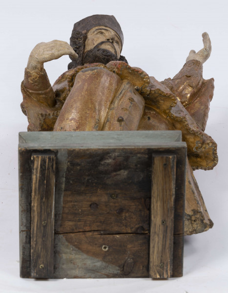 E/16816/ML - Rzeźba drewniana, pełna, polichromowana, przedstawiająca św. Jana Nepomucena. Kompozycja frontalna. Postać stojąca w kontrapoście – prawa noga zgięta i wysunięta do przodu. Sylwetka przechylona na prawo. Lewa ręka zgięta w łokciu i wysunięta do przodu. Prawa zgięta, uniesiona do góry. Brak atrybutów (krzyża i palmy) w dłoniach.
Postać ubrana w sutannę, komżę drapowaną w fałdy i zakończoną koronką, płaszcz z kapturem. Ślady złoceń na partii ubrania. Głowa skierowana na prawo. Twarz podłużna (kolor kremowy), usta proste, oczy z zaznaczonymi na ciemno tęczówkami, nos prosty, lekko zaznaczone kości policzkowe. Wolutowe pukle brody i włosów, symetryczne. Na głowie ciemnobrązowy biret. Stopy wystające spod sutanny.

Konserwacja: 2001 r.