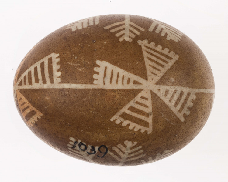 E/1039/ML - Technika batik. Podział podłużny na 2 części. Motyw gwiazdy, krzyża, swastyki. Barwa tła brązowa, barwa motywu biała i ceglasta.