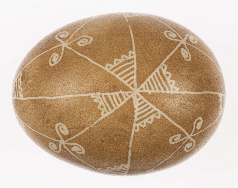 E/1232/ML - Technika batik. Podział na podłużny na 4 części, podział poprzeczny na 2 części. Na skrzyżowaniu linii motyw swastyki, Wewnątrz pól motyw trykwetru. Barwa tła brązowa, barwa motywu biała.