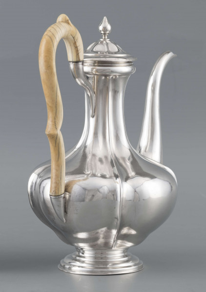 S/Mt/514/ML - Kafetiera w kształcie tralki o brzuscu pękatym i smukłej szyjce, profilowana a żeberkowaniem, na niskiej stopie. Wylew w formie dziobka, ucho kościane z okrągłego wałka, profilowane, osadzone w dwóch tulejkach, pokrywka wysklepiona, z wystającą kryzą i uchwytem w kształcie cebulki. Wnetrze złocone.
Na dnie sygnatura:
- imienna 