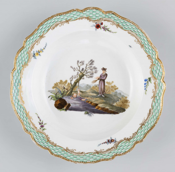 S/CS/1580/ML - Talerz głęboki o falistym wykroju brzegu. Na dnie malowana barwna miniatura przedstawiajaca scenkę w pejzażu: chłopiec wpadł do strumienia i trzyma się gałązki wierzby rosnacej na brzegu, obok stoi nauczyciel z rózgą w ręce. Na kołnierzu malowana mozaika w kolorze zieleni miedziowej, obramowana od środka złotymi rocaille'ami z piecioma rzuconymi gałązkami. 
Na spodzie napis wykonany naszkliwnie purpurą: 