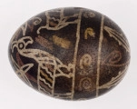 E/1323/ML - Technika batik. Podział poprzeczny na 2 nierówne części. Motyw zwierzęcy (koza, ptaszki) i roślinny. Barwa tła czarna, barwa motywu biała, żółta i ceglasta.