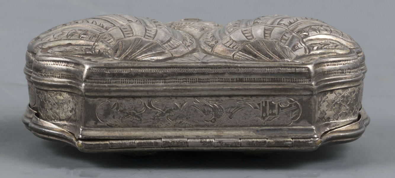 S/Mt/566/ML - Denko puklowane w formie dwóch złożonych symetrycznie muszli, zdobionych rzędami kampanuli i podobnie uformowane wieczko, z bogatszą dekoracją. Na powierzchni muszli relief przedstawiający dwa hipokampy z zakręconymi rybimi ogonami - prawy z głową konia, lewy z głowa orła - dosiadane przez putta. W polach między muszlami na dole slimak, u góry wąż. Ścianki boczne grawerowane : elementy pejzażu, ptak, królik, kwiaty i kratka regencyjna. Wnętrze złocone.
 Wewnątrz na denku i wieczku powtórzone punce ze znakami:
- miejska Paryża z 1. poł XVIII w. (litera S pod koroną
- złotnika o inicjałach 