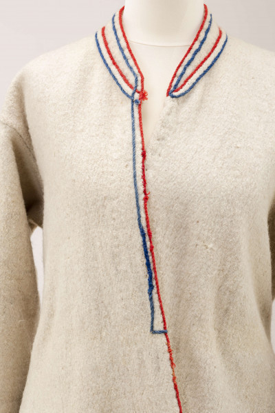 Sukmana kobieca, odświętna, szyta ręcznie z samodziałowego, folowanego sukna w kolorze białym. Nieodcinana w talii, przody bez zapięcia. Rękawy długie, lekko zwężone ku dołowi. Na bokach poniżej talii wstawione trójkątne kliny, które tworzą fałdy. W szwach łączących przody z klinami – tzw. ślepe kieszenie. Ozdobiona czerwonym i granatowym sznureczkiem wełnianym: na kołnierzyku, na przodzie,  dole rękawów oraz na bokach poniżej talii i przy kieszeniach. Często przepasywana była wełnianą krajką.