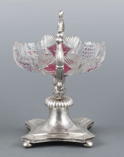 S/Mt/384/ML - Czara ze szkła bezbarwnego, miejscami barwionego powierzchniowo, płytka, owalna, profilowana, z dekoracją szlifowaną (wachlarzyki i szlif brylantowy) i trawioną (wzór kwiatowy) - utrzymana w stylu biedermeier. Umieszczona na figurce delfina z podstawą czworoboczną o wklęsłych bokach i ściętych narożach, z nóżkami w kształcie spłaszczonych kulek. Po bokach czary ucha w formie wolut z liśćmi akantu i motywem łabędzi. Brzeg podstawy obiega pas wici różanej.
Na brzegu podstawy sygnatura wklęsła kursywą: 
-  