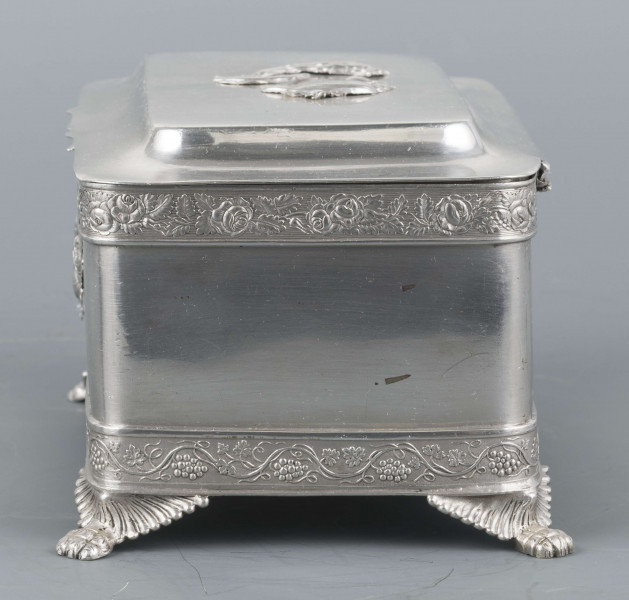 S/Mt/354/ML - Cukiernica prostokątna o lekko zaokrąglonych narożach, na czterech nóżkach w formie uskrzydlonych lwich łap, z profilowanym wieczkiem. Brzegi obwiedzione moletowaną taśmą: u dołu z motywem winnej łozy, u góry - wici różanej.Szyld zamka zdobi plakieta z girandą róż, druga - na wieczku - jest uszkodzona a przez to nieczytelna.
Na dnie sygnatury kursywa we wklesłych owalnych ramkach:
- K.Rotkiel
- w lublinie
Przedzielone okrągłą puncą z próbą 