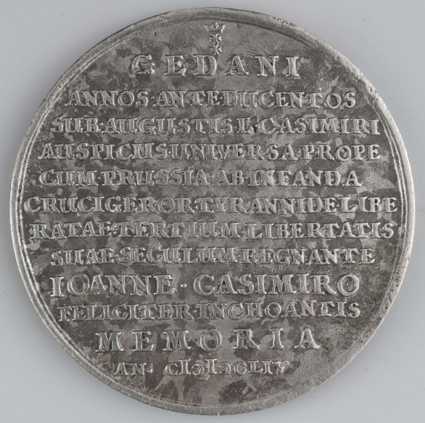 N/1523/ML - AV. W ziarnistej obwódce na schodkowym postumencie Orzeł pruski nad nim napis PRUS - SIA i orzeł koronny, a wyżej gloria z hebrajskim napisem: Jahwe. W tle równina z miastami, zamkiem i rzekami. Na dole mała tarcza Zakonu Krzyżackiego rozdziela litery I - H, monogram autora medalu. W otoku napis poprzedzony rozetką:
TEUTONICOS PEPULIT VIRTUS PRUTENICA : PULCHRUM NUMINIS ET REGIS CURA TUETUR OPUS

RV. Poniżej małego herbu Gdańska dwunastowierszowy napis;
GEDANI / ANNOS . ANTE . DUCENTOS / SUB . AUGUSTIS . (D) . CASIMIRI / AUSPICIIS . UNIVERSA . PROPE / CUM . PRUSSIA . AB . INFANDA / CRUCIGEROR . TYRANNIDE . LIBE / RATE . TERTIUM . LIBERTATIS / SUAE . SECULUM . REGNANTE / IOANNE . CASIMIRO / FELICITER . INCHOANTIS / MEMORIA / AN . C I ) I ) L I V
