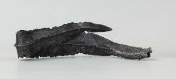 Żelazny grot broni drzewcowej zdobiony wyjątkową, srebrną inkrustacją jest częścią uzbrojenia włożonego do grobu ciałopalnego wojownika z początku III w. n.e. 
Grób przedstawiciela ludności kultury przeworskiej został odkryty przypadkowo w 1959 roku. 
Oprócz trzech grotów, pochówkowi wojownika towarzyszyły: żelazne umbo, dwie ostrogi, tok brązowy (prawdopodobnie okucie drzewca oszczepu) a także żelazny miecz z miedziana inkrustacją wyobrażającą rzymskich bogów. Pochowany na terenie obecnej wsi Podlodów wojownik należał do elity wojskowej przedstawicieli kultury przeworskiej. Liść grotu jest smukły i długi, a u podstawy cylindrycznej i krótkiej tulejki znajduje się żeberko. Na obydwu częściach grotu znajdują się zdobienia inkrustowane srebrem - znaki o znaczeniu symbolicznym: trójkąty sferyczne, punkty, podwójne widełki. Przypominają one symbole religijne (ewentualnie znaki magiczne lub własnościowe) - tamgi. Niektórzy badacze zakładają, że mogły one zostać przejęte przez Sarmatów. 
Wymiary dodatkowe: szer. 4,0 cm 