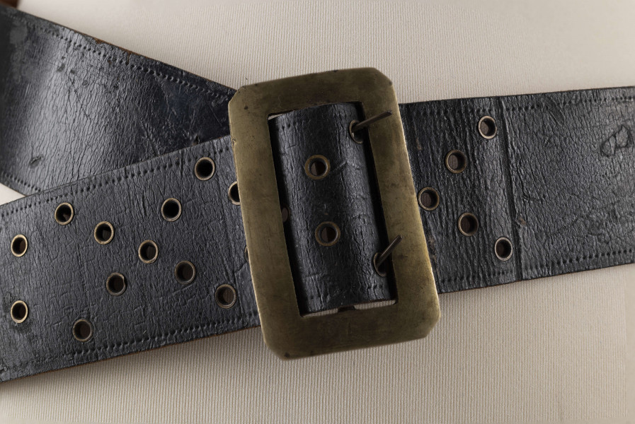 E/706/ML - Pas męski wykonany ze skóry koloru czarnego, z mosiężną klamrą. Ozdobiony ornamentem w postaci punktów wytłaczanych stemplem. Dziurki obłożone mosiężnymi kółeczkami.