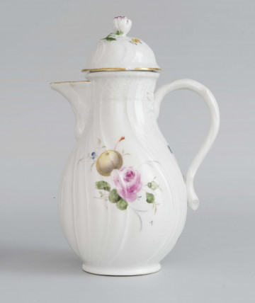 Dzbanek gruszkowaty na pierścieniowej podstawie, uchwyt okrągły z liściastymi ornamentami w osadzeniach, wylew z dziobkiem. Pokrywka kopulasto wysklepiona z uchwytem w kształcie pączka róży. Powierzchnia ukośnie kanelowana z plecionką wokół górnej krawędzi  - w typie Neu Ozier,  podobnie opracowana pokrywka, Na brzuścu wielobarwna dekoracja w formie pęków kwiatów, owoców i warzyw; po jednej stronie: stokrotki, marchew i filetowa śliwka, po drugiej - róża i żółta śliwka. Na pokrywce drobne gałązki kwiatowe.
 