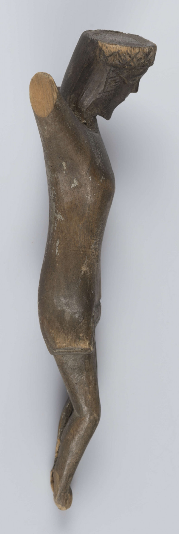 E/420/ML - Rzeźba wykonana techniką strugania i gładzenia z jednego kawałka drewna. Głowa lekko pochylona ku przodowi i w prawo. Perizonium schematyczne, twarz stylizowana, oczy zamknięte, na ustach widoczny smutek. Korona cierniowa zaznaczona wyraźnie - ciernie symboliczne - wgłębne iksy oraz kropki. Rzeźba niepolichromowana.