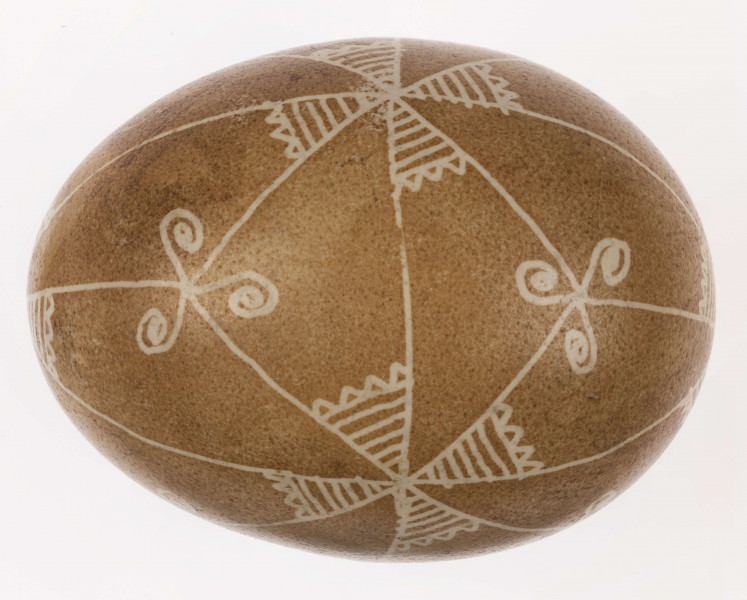 E/1232/ML - Technika batik. Podział na podłużny na 4 części, podział poprzeczny na 2 części. Na skrzyżowaniu linii motyw swastyki, Wewnątrz pól motyw trykwetru. Barwa tła brązowa, barwa motywu biała.