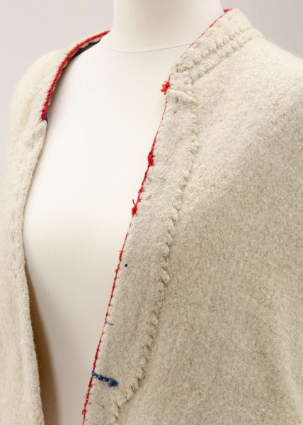 Sukmana kobieca, odświętna, szyta ręcznie z samodziałowego, folowanego sukna w kolorze białym. Nieodcinana w talii, przody bez zapięcia. Rękawy długie, lekko zwężone ku dołowi. Na bokach poniżej talii wstawione trójkątne kliny, które tworzą fałdy. W szwach łączących przody z klinami – tzw. ślepe kieszenie. Ozdobiona czerwonym i granatowym sznureczkiem wełnianym: na kołnierzyku, na przodzie,  dole rękawów oraz na bokach poniżej talii i przy kieszeniach. Często przepasywana była wełnianą krajką.