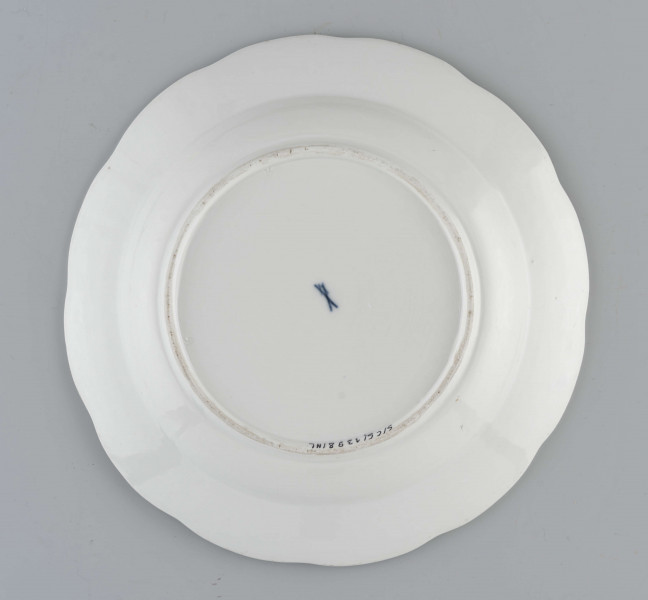 Talerz okrągły o falistym brzegu. Dno płaskie, kołnierz ukośnie odchylony pokryty reliefem plecionkowym z tzw. splotem Sułkowskiego, z podziałęm na 12 pól. Dekoracja malarska rozmieszczona nieregularnie na dnie półmiska: krzak peonii z chrabąszczem majowym, skrzydlaty smok i lecąca czapla. Na kołnierzu drobne gałązki kwiatowe na przemian z motylami. Barwy: błękit, czerwień, zieleń groszkowa i turkusowa, purpura, żółcienie, brąz i czerń.
Na spodzie sygnatura kobaltowa pod szkliwem: dwa skrzyżowane miecze.