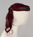 E/516/ML - Czepek mężatki. Denko wewnętrzne wykonane z plecionej siatki zielonej. Z wierzchu chustka fabryczna koloru ciemnoczerwonego w kwiaty wiązana na tekturowej obręczy. Końce chustki zwisają do tyłu.