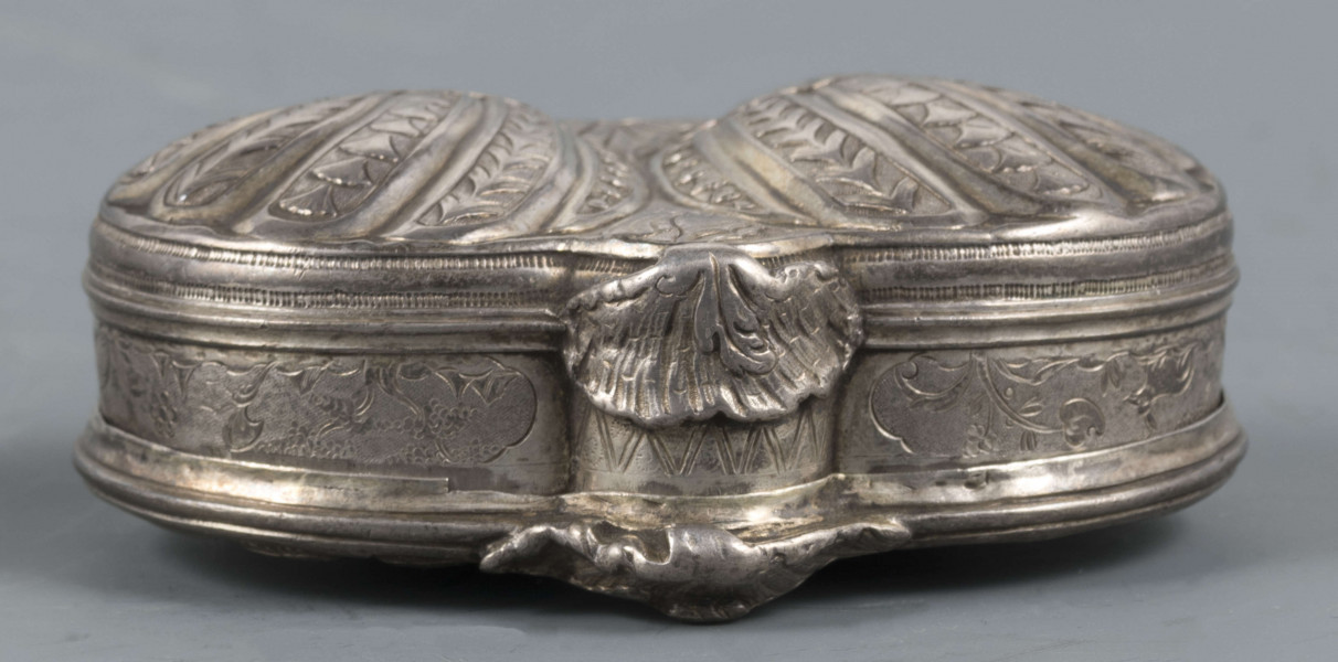 S/Mt/566/ML - Denko puklowane w formie dwóch złożonych symetrycznie muszli, zdobionych rzędami kampanuli i podobnie uformowane wieczko, z bogatszą dekoracją. Na powierzchni muszli relief przedstawiający dwa hipokampy z zakręconymi rybimi ogonami - prawy z głową konia, lewy z głowa orła - dosiadane przez putta. W polach między muszlami na dole slimak, u góry wąż. Ścianki boczne grawerowane : elementy pejzażu, ptak, królik, kwiaty i kratka regencyjna. Wnętrze złocone.
 Wewnątrz na denku i wieczku powtórzone punce ze znakami:
- miejska Paryża z 1. poł XVIII w. (litera S pod koroną
- złotnika o inicjałach 