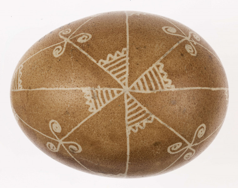 E/1232/ML - Technika batik. Podział na podłużny na 4 części, podział poprzeczny na 2 części. Na skrzyżowaniu linii motyw swastyki, Wewnątrz pól motyw trykwetru. Barwa tła brązowa, barwa motywu biała.