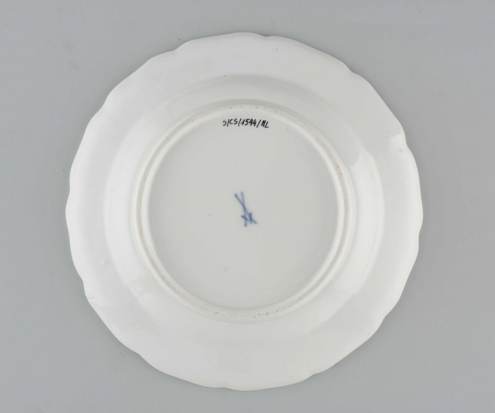 Talerz okrągły o falistym brzegu i pogrubionej krawędzi. Dno płaskie, kołnierz ukośnie odchylony pokryty reliefem plecionkowym z tzw. splotem Sułkowskiego. Dekoracja malarska w stylu Kakiemon rozmieszczona nieregularnie. Na dnie: dwa barwne ptaki (kukułki) siedzące na gałązce, nad nimi kwitnące chryzantemy. Na kołnierzu drobne gałązki kwiatowe na przemian z motylami. Barwy: błękit, czerwień, zieleń, żółcień, brąz i czerń.
 