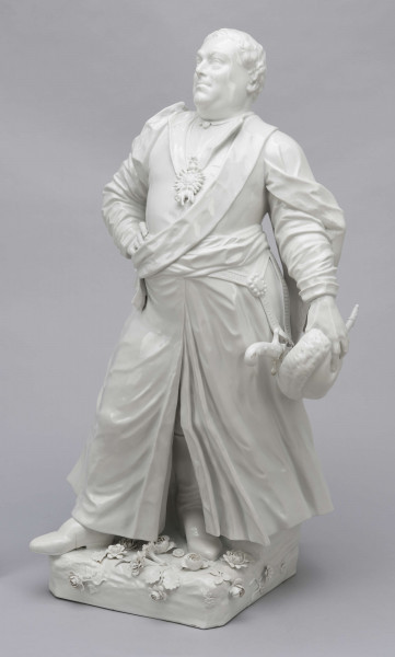 S/CS/657/ML - Figura z białej porcelany przedstawia króla Augusta III en pied na cokole zdobionym plastycznie modelowanymi różami i goździkami. Król stoi w kontrapoście, z lekko uniesioną głową, prawą rękę opiera na biodrze, w lewej opuszczonej trzyma czapkę okrągłą obszytą futrem. Ubrany jest w polski strój szlachecki: żupan, kontusz z zarzuconymi wylotami i pas. Na piersi ma order Złotego Runa i wstęgę z krzyżem orderu Orła Białego, przy lewym boku szablę na ozdobnych rapciach.
Figura stanowi wierne odwzorowanie portretu króla wykonanego przez Louis de Silvestre'a nadwornego malarza ok. roku 1737 (obecnie w zbiorach Muzeum w Wilanowie).