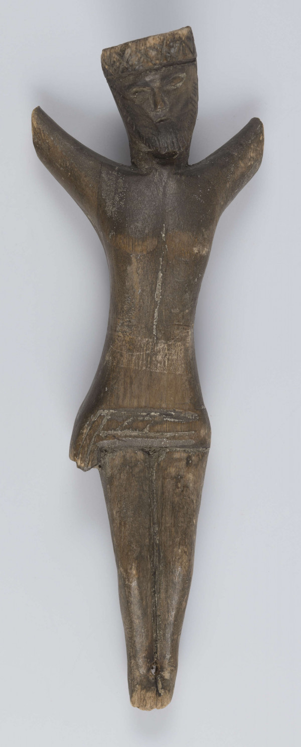 E/420/ML - Rzeźba wykonana techniką strugania i gładzenia z jednego kawałka drewna. Głowa lekko pochylona ku przodowi i w prawo. Perizonium schematyczne, twarz stylizowana, oczy zamknięte, na ustach widoczny smutek. Korona cierniowa zaznaczona wyraźnie - ciernie symboliczne - wgłębne iksy oraz kropki. Rzeźba niepolichromowana.