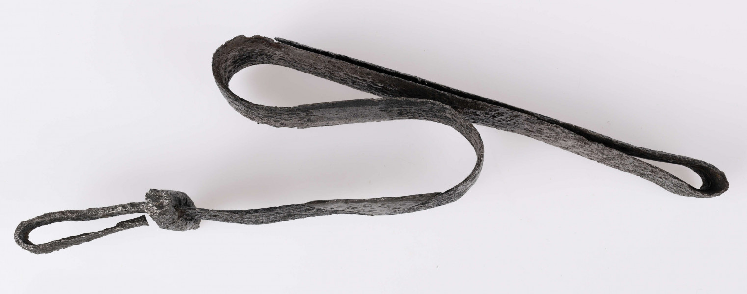 Miecz żelazny, obosieczny, bez strużyn. U podstawy trzpienia znajduje się krótki, prosty w przekroju czworoboczny jelec. Kolec prosty na końcu rozklepany. Miecz rytualnie zgięty.