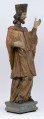 E/16816/ML - Rzeźba drewniana, pełna, polichromowana, przedstawiająca św. Jana Nepomucena. Kompozycja frontalna. Postać stojąca w kontrapoście – prawa noga zgięta i wysunięta do przodu. Sylwetka przechylona na prawo. Lewa ręka zgięta w łokciu i wysunięta do przodu. Prawa zgięta, uniesiona do góry. Brak atrybutów (krzyża i palmy) w dłoniach.
Postać ubrana w sutannę, komżę drapowaną w fałdy i zakończoną koronką, płaszcz z kapturem. Ślady złoceń na partii ubrania. Głowa skierowana na prawo. Twarz podłużna (kolor kremowy), usta proste, oczy z zaznaczonymi na ciemno tęczówkami, nos prosty, lekko zaznaczone kości policzkowe. Wolutowe pukle brody i włosów, symetryczne. Na głowie ciemnobrązowy biret. Stopy wystające spod sutanny.

Konserwacja: 2001 r.