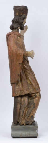 E/16816/ML - Rzeźba drewniana, pełna, polichromowana, przedstawiająca św. Jana Nepomucena. Kompozycja frontalna. Postać stojąca w kontrapoście – prawa noga zgięta i wysunięta do przodu. Sylwetka przechylona na prawo. Lewa ręka zgięta w łokciu i wysunięta do przodu. Prawa zgięta, uniesiona do góry. Brak atrybutów (krzyża i palmy) w dłoniach.
Postać ubrana w sutannę, komżę drapowaną w fałdy i zakończoną koronką, płaszcz z kapturem. Ślady złoceń na partii ubrania. Głowa skierowana na prawo. Twarz podłużna (kolor kremowy), usta proste, oczy z zaznaczonymi na ciemno tęczówkami, nos prosty, lekko zaznaczone kości policzkowe. Wolutowe pukle brody i włosów, symetryczne. Na głowie ciemnobrązowy biret. Stopy wystające spod sutanny.

Konserwacja: 2001 r.