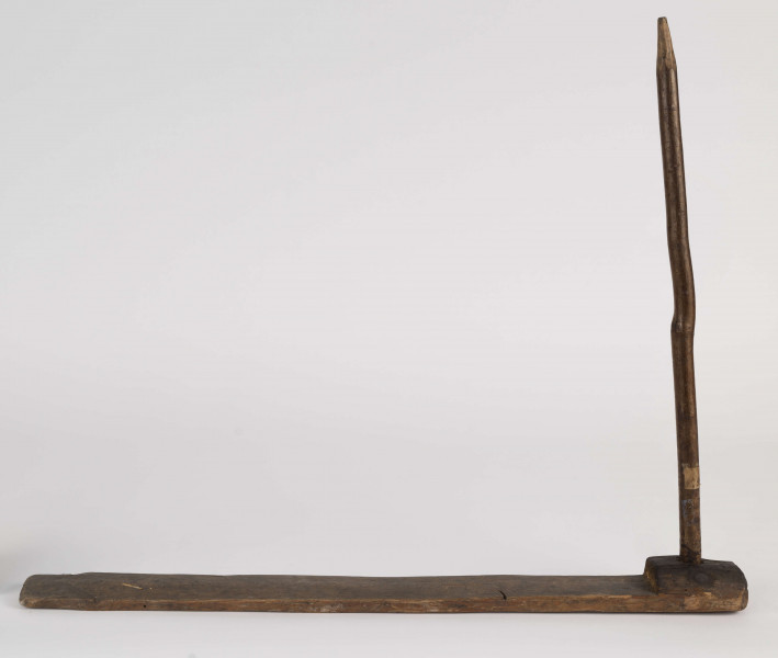 E/944/ML - Przęślica krężołkowa z przysiadką. Złożona z grubej poziomej przysiadki, w której przy jednym końcu osadzona jest pionowa beleczka, zw. piórem. Krężla brak. Podstawa ma przekrój kwadratowy. Przęślica wykonana z drewna sosny, pióro z leszczyny. Zarówno pióro, jak i przysiadka, nie jest pokryta żadnym ornamentem. Służyła do umocowywania wełny, lnu czy konopi, przy wiciu przędzy za pomocą wrzeciona.