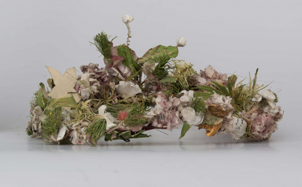 E/540/ML - Ubiór głowy kobiecy w formie wianka wykonany z różnokolorowych kwiatów z płótna oraz zielonych listków. Całość umocowana na drucie.
