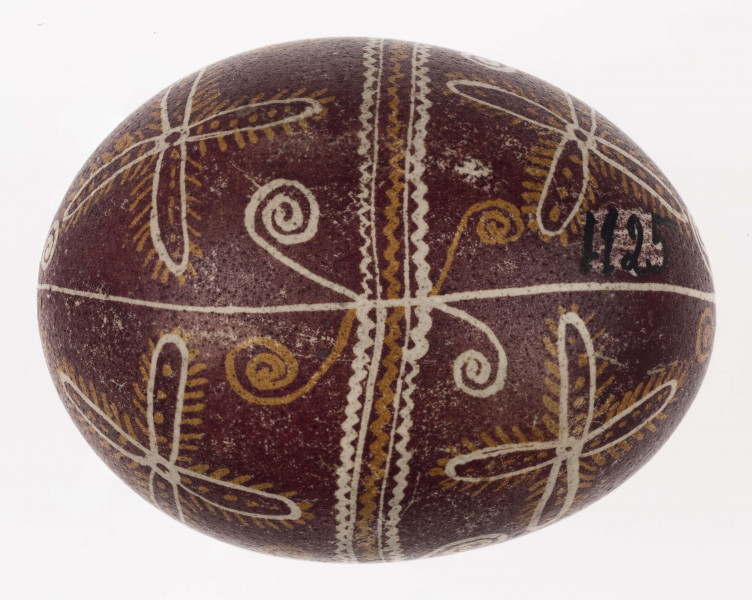 E/1125/ML - Technika batik. Podział podłużny na 4 części, podział poprzeczny 2 części. Motyw swastyki i krzyża. Barwa tła ciemnoburaczkowa, barwa motywu biała i żółta.