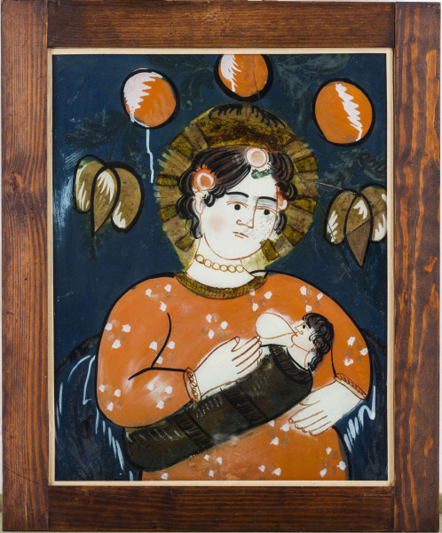 Obraz na szkle. Tło granatowe. W centrum postać Madonny w ceglastej sukience, w białe i beżowe kropki. Przy szyi złota lamówka. Madonna karmi Dzieciątko, zawinięte w brązowo-czarna tkaninę. Ręce, twarz, szyja postaci białe. Kontury podkreślone brązową farbą. Włosy brązowe, loki podkreślone kolorem czarnym. We włosach Madonny trzy kuliste różowe kwiaty. Wokół głowy złota aureola. Nad głową Madonny trzy kuliste ceglaste kwiaty, cieniowane białą farbą. Ledwo widoczne zielone listki. Po bokach głowy stylizowane pojedyncze brązowe tulipany. Ich kontury obwiedzione czarnym kolorem. Twarz z lekkim rumieńcem. Brwi i oczy czarne; pomiędzy powiekami a brwiami szare cienie. 