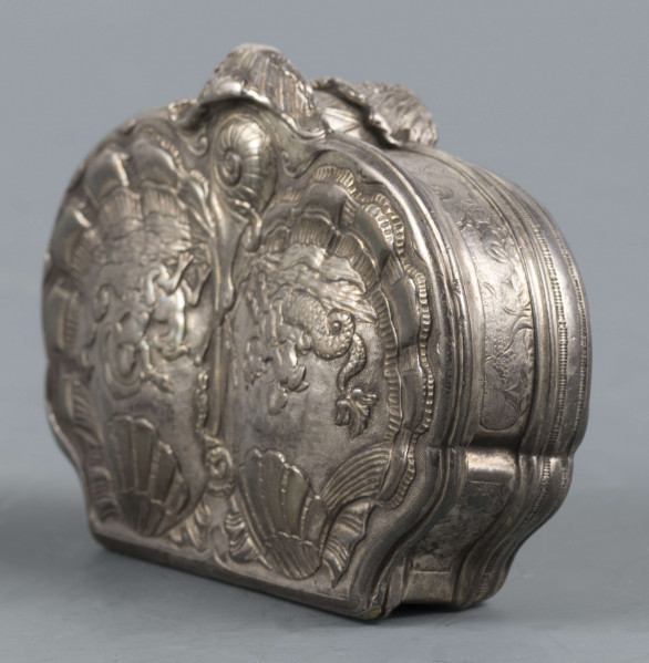 S/Mt/566/ML - Denko puklowane w formie dwóch złożonych symetrycznie muszli, zdobionych rzędami kampanuli i podobnie uformowane wieczko, z bogatszą dekoracją. Na powierzchni muszli relief przedstawiający dwa hipokampy z zakręconymi rybimi ogonami - prawy z głową konia, lewy z głowa orła - dosiadane przez putta. W polach między muszlami na dole slimak, u góry wąż. Ścianki boczne grawerowane : elementy pejzażu, ptak, królik, kwiaty i kratka regencyjna. Wnętrze złocone.
 Wewnątrz na denku i wieczku powtórzone punce ze znakami:
- miejska Paryża z 1. poł XVIII w. (litera S pod koroną
- złotnika o inicjałach 