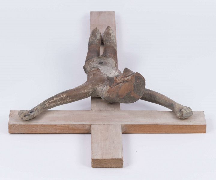 E/367/ML - Rzeźba w glinie przedstawiająca Chrystusa Ukrzyżowanego. Głowa schylona lekko w prawa stronę. Ciało nagie. Nogi podkulone i przebite żelaznym gwoździem. Glina wypalona.