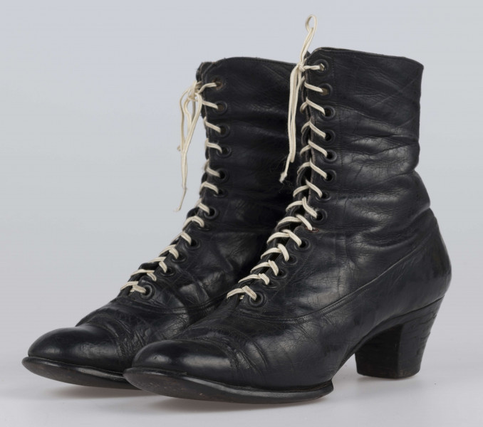 E/11811/ML - Buty odświętne, z czarnej licowej skóry. Wewnątrz płócienna podszewka. Obcas słupowaty wys. 5 cm. Podeszwy ze skóry. Cholewka wys. 10 cm, dopasowana do nogi, z przodu sznurowana. Nosek zwężony, na końcu ścięty. Wykrój podeszew w obu butach identyczny – lewy równa się prawemu.