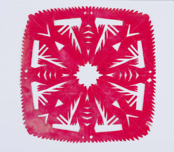 Wycinanka w formie kwadratu z różowego glansowanego papieru. Brzeg nierówno ząbkowany. W środku krzyż o postrzępionych brzegach i ażurowanym w gwiazdę środku. Spomiędzy ramion wyrastają promienie. Wycinanka naklejona na białym kartonie.