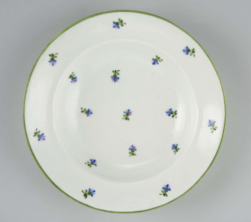 Talerz głęboki, okrągły, gładki, zdobiony malowanym rzutem drobnych chaberków z błękitnymi kwiatkami i zielonymi listkami, krawędź obwiedziona zielonym konturem.
Na spodzie malowane znaki:
 