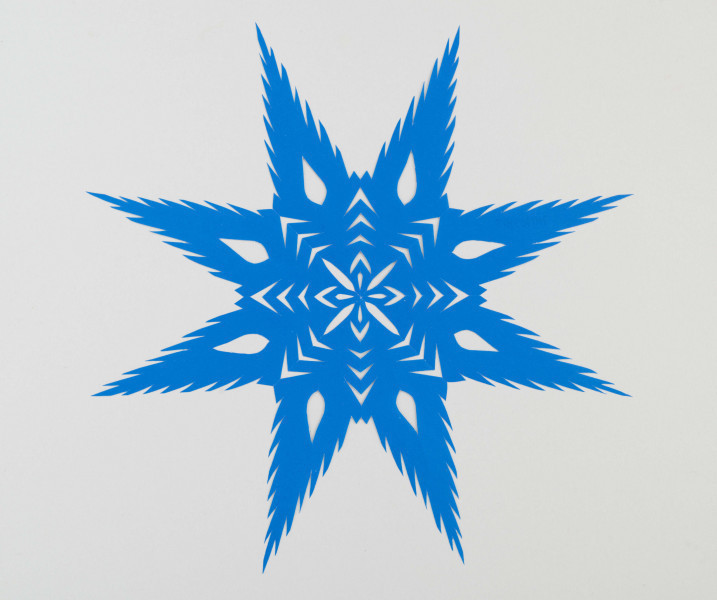 Wycinanka koloru szafirowego - gwiazda 8ramienna, wykończona ząbkami. W środku układ ze strzałek i nacięć w formie płatków.