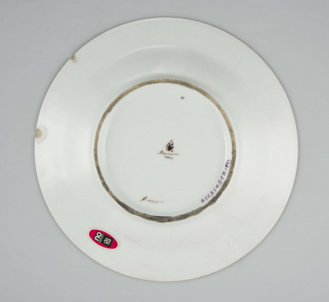 Talerz płytki, okrągły, gładki, brzeg obwiedziony szerokim złotym paskiem, na kołnierzu malowany herb 