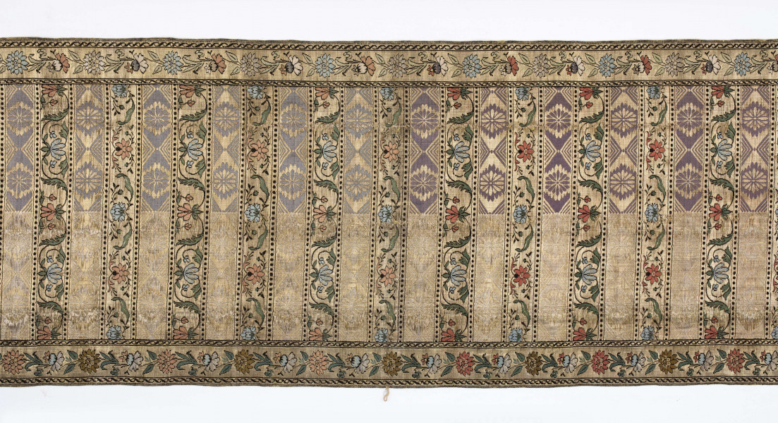 Pas kontuszowy 4-stronny
Ornament:
głowy - dwa motywy ukwieconych rozet wpisanych w owalne medaliony
środek - poprzeczne pólka w układzie a,b,a,c
a - z motywem rombów z rozetami
b i c - z dwoma odmiennymi motywami zgeometryzowanej wici kwiatowej
obrzeżenia - z motywem gałązek kwiatowych 
obwódki pionowe w przeplatające się wężyki, poziome w kółeczka
Kolor:
pr. - tło złote, ornement  - kwiaty w głowach i pólkach b, c, na przemian łososiowe i jasnoniebieskie, listki zielone, gałązki i kontury czarne, romby w pólkach a w połowie niebieskie, w połowie białe
l. - tło czarne, pólka a w połowie czerwone, w połowie zielone, 
Frędzla doszyta, pleciona, złota
W narożnikach sygnatura wytkana w prostokącie: 