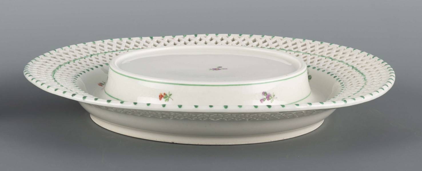 S/CS/1371/ML - Kosz konicznie wgłębiony, kołnierz ażurowy - w dolnej części pionowe równoległe pręty, w górnej ukośna kratownica), wylew obwiedziony półwałkiem. Dekoracja malowana barwnie: lustro obwiedzione wicią winorośli z trzema gałązkami niezapominajek, elementy koszykowe konturowane zielenią, krawędzie od zewnątrz podkreślone błękitnymi pionowymi kreskami.  