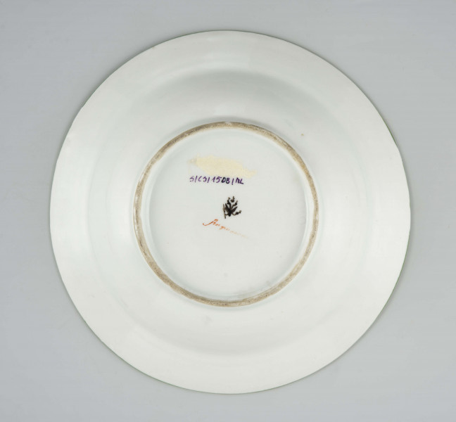 Talerz głęboki, okrągły, gładki, zdobiony malowanym rzutem drobnych chaberków z błękitnymi kwiatkami i zielonymi listkami, krawędź obwiedziona zielonym konturem.
Na spodzie malowane znaki:
 