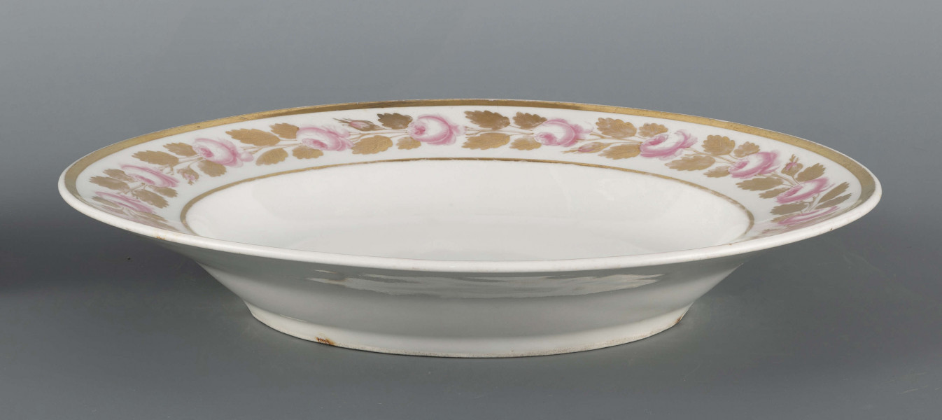 S/CS/1491/ML - Talerz płytki, okrągły, gładki. Kołnierz zdobiony malowaną girlandą różowych różyczek ze złotymi listkami ujętą w złote paski. Pośrodku lustra podwójne złote kółko.
 