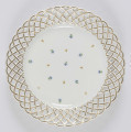 S/CS/1434/ML - Talerz płytki, okrągły, kołnierz ażurowy w formie plecionki  koszykowej podkreślonej złotym konturem. W lustrze dekoracja malowana - drobny rzur chaberków, 
 