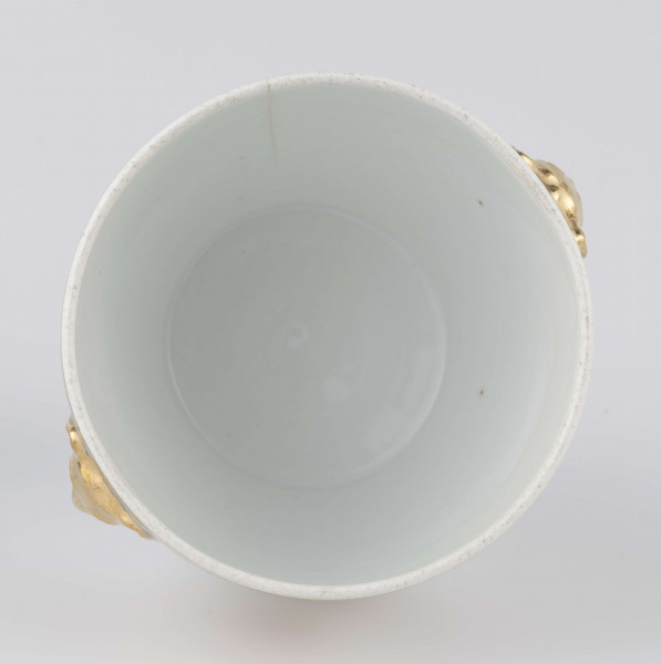 S/CS/1388/2/ML - Cukiernica półowoidalna z uchwytami w formie półplastycznych lwich głów i pokrywką w kształcie ściętego stożka o wklęsłych bokach z kulistym uchwytem. Dekoracja malowana wielobarwnie i złocona: brzusiec i boki pokrywki obiega szeroki fryz złożony ze stylizowanych ornamentów roślinnych (gałązek, kłosów zbóż i liści akantu)  połączonych z owalnymi medalionami, w których są trzy różowe różyczki z zielonymi listkami na złotym tle.Uchwyty malowane złotem,  złotym konturem obwiedzione wszystkie krawędzie.
 