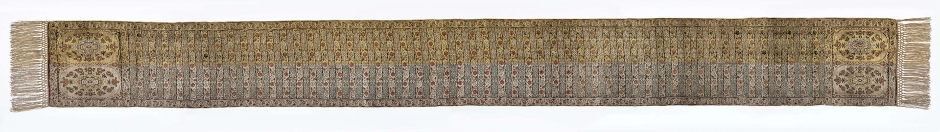 Pas kontuszowy czterostronny.
Ornament:
głowy - dwa motywy ukwieconych rozet wpisanych w owalne medaliony
środek - poprzeczne pólka na przemian z motywami wici kwiatowej i połączonych rozet, obrzeżenia pionowe i poziome z wicią jak w pólkach
obwódki - w trójkąciki
Kolor:
tło - w połowie srebrne, w połowie złote
ornament - kwiaty jasnoczerwone w głowach, w pólkach na przemian jasnoczerwone i białe, listki zielone, gałązki i trójkąciki czarne
strona lewa w połowie zielona w połowie czerwona
Frędzla wiązana, doszyta, w połowie srebrna, w połowie złota
Sygnatura wytkana w narożnikach obu głów: 