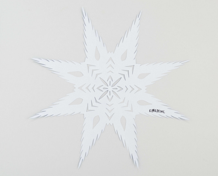 Wycinanka koloru szafirowego - gwiazda 8ramienna, wykończona ząbkami. W środku układ ze strzałek i nacięć w formie płatków.