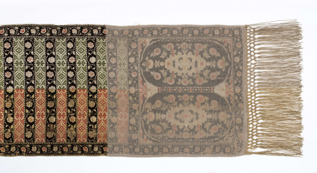 Pas kontuszowy czterostronny.
Ornament:
głowy - dwa motywy ukwieconych rozet wpisanych w owalne medaliony
środek - poprzeczne pólka na przemian z motywami wici kwiatowej i połączonych rozet, obrzeżenia pionowe i poziome z wicią jak w pólkach
obwódki - w trójkąciki
Kolor:
tło - w połowie srebrne, w połowie złote
ornament - kwiaty jasnoczerwone w głowach, w pólkach na przemian jasnoczerwone i białe, listki zielone, gałązki i trójkąciki czarne
strona lewa w połowie zielona w połowie czerwona
Frędzla wiązana, doszyta, w połowie srebrna, w połowie złota
Sygnatura wytkana w narożnikach obu głów: 