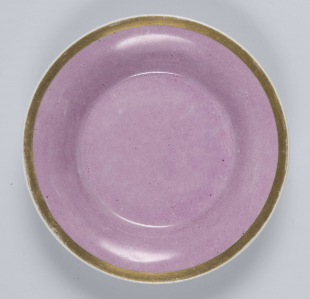 S/CS/133/2/ML - Spodek okrągły, wgłębiony, gładki, z rozchylonym kołnierzem. 
Powierzchnia matowa malowana w całości na różowy kolor, wylew  obwiedziony złotym paskiem.
