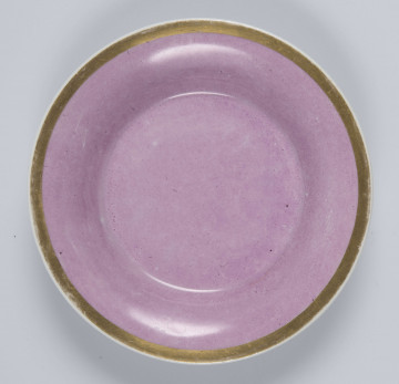 S/CS/133/2/ML - Spodek okrągły, wgłębiony, gładki, z rozchylonym kołnierzem. 
Powierzchnia matowa malowana w całości na różowy kolor, wylew  obwiedziony złotym paskiem.
